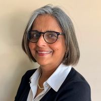 Kavita Pandit from Georgia State University, smiling in a smart business attire against a soft beige background.