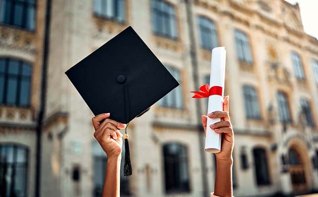 graduate holding academic hat and diploma with red ribbon. Happy graduation, bright future, success and confidence.