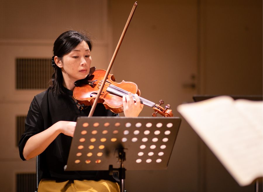 female musician playing the violin in a music hall