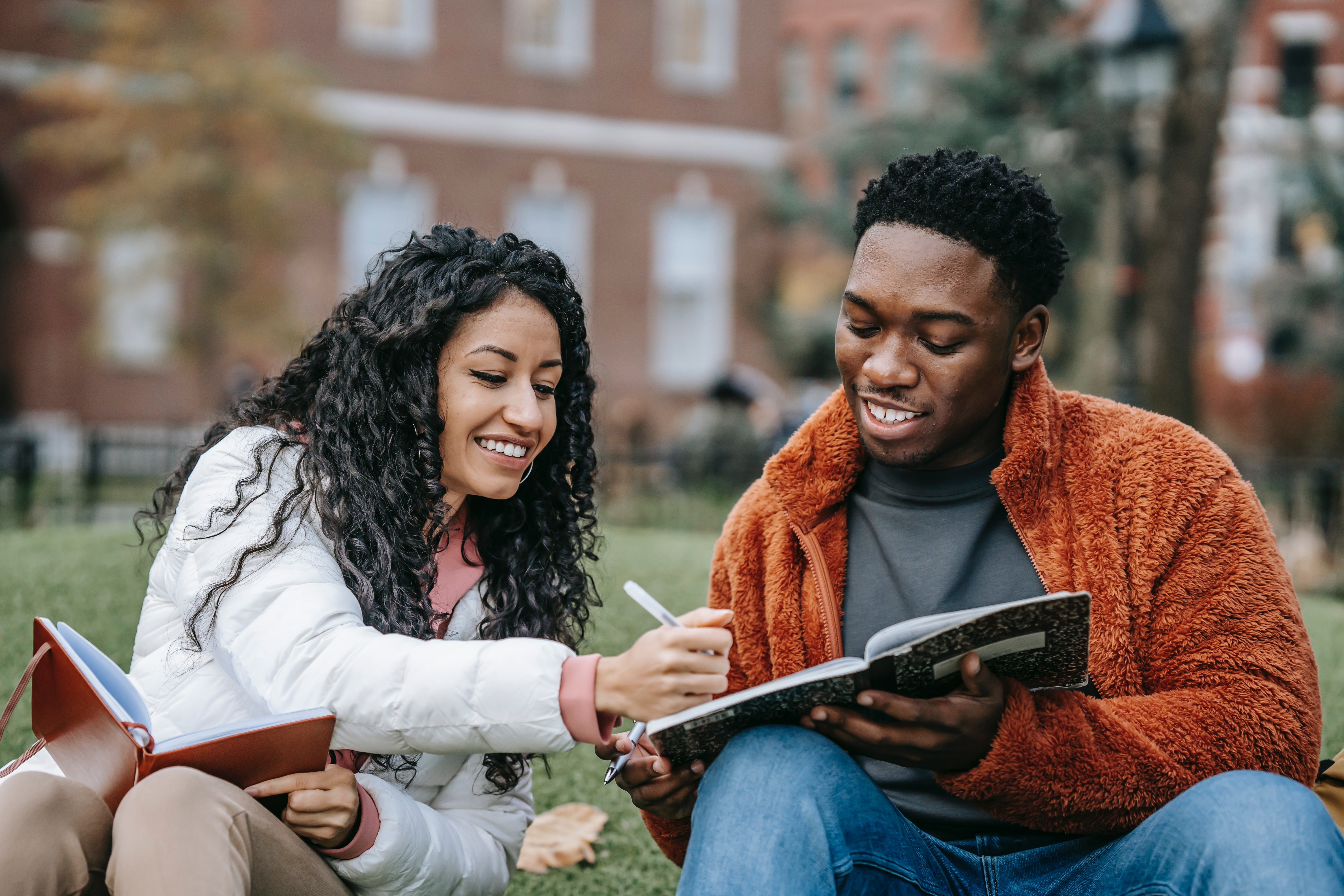 two students studying outside their college campus