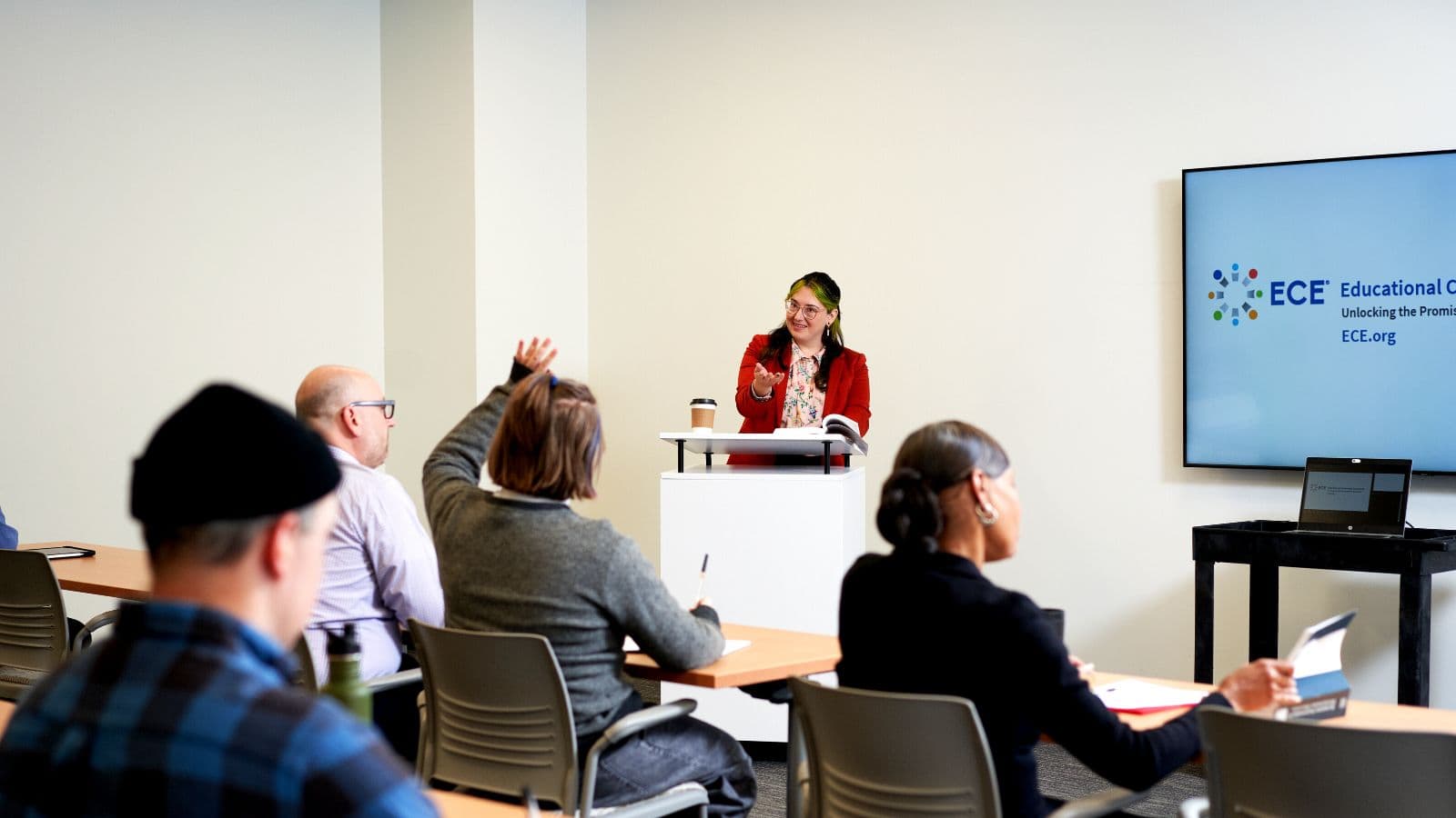 An ECE® evaluator standing at a podium answering a question during a presentation