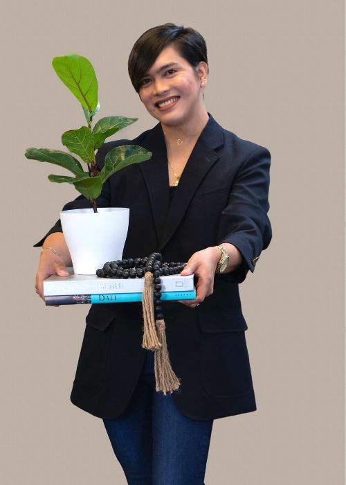 Fritz Peterson balances a potted plant and books, ready to nurture growth.