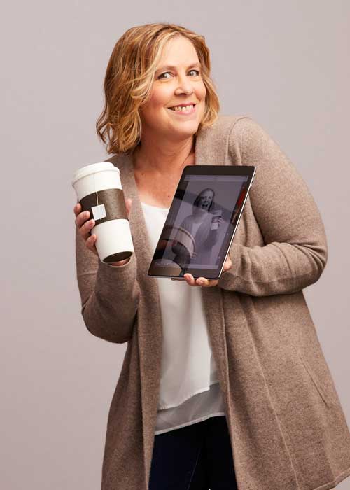 Heidi Ames holding a coffee cup and a tablet conveying love for coffee and tech.