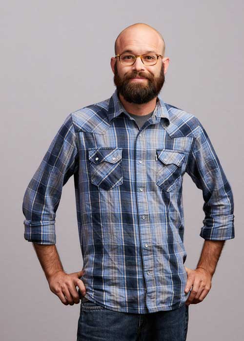 evin DeMars looking relaxed in a blue and grey plaid shirt, with a slight smile.