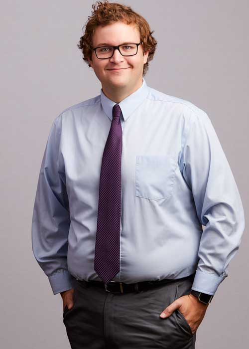 Nick Kelley looking smart in a light blue shirt and burgundy tie, with a friendly and approachable demeanor.