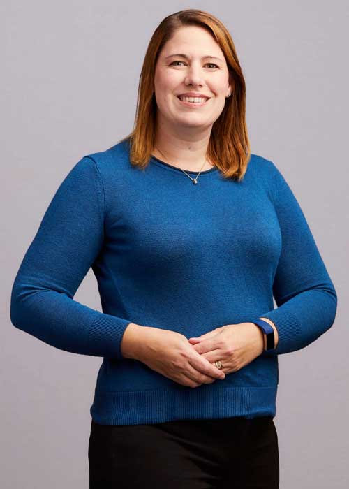 Sheree Yates in a professional portrait, wearing a blue sweater and smiling warmly at the camera.